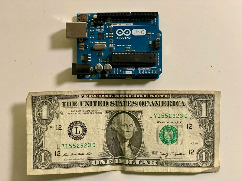 Image of an Arduino next to a dollar bill for scale.